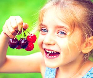 Bambina che mangia ciliegie